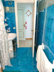 Baño azul con aseo y lavamanos en Apartment for holiday rent in Marina di Cecina, en Cecina