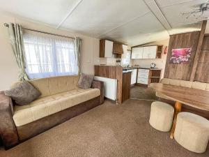 勞斯的住宿－Lovely 8 Berth Caravan With Decking At Sunnydale Park, Lincolnshire Ref 35091br，带沙发的客厅和厨房