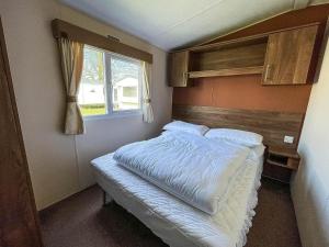 a bedroom with a large bed with a window at Lovely 8 Berth Caravan With Decking At Sunnydale Park, Lincolnshire Ref 35091br in Louth