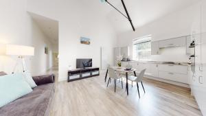 sala de estar blanca con mesa y cocina en Spacious three bedroom apartment with Valley views en Abertillery
