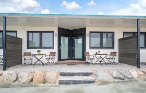 a house with chairs and tables in front of it at Apartments Waterfront in Sagard