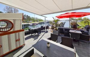 a patio with tables and chairs and an umbrella at Apartments Waterfront in Sagard