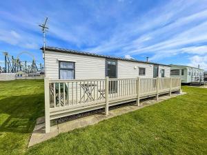 a white house with a fence and a playground at Lovely 8 Berth Caravan With Decking At Eastgate Fantasy Island Park Ref 58004c in Skegness