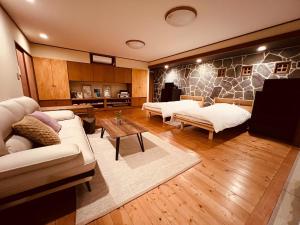 Sala de estar con 2 sofás y mesa en Yufuin Tsukawara Kogen Sanctuary - Vacation STAY 91378v, en Yufu