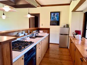 a large kitchen with a sink and a refrigerator at Yufuin Tsukawara Kogen Sanctuary - Vacation STAY 91378v in Yufu