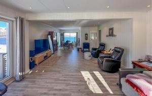uma sala de estar com um sofá e uma televisão em Cozy Home In Stokmarknes With House A Mountain View em Stokmarknes