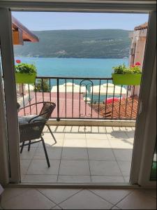 a balcony with a view of a pool and the ocean at Apartments Sun House in Herceg-Novi