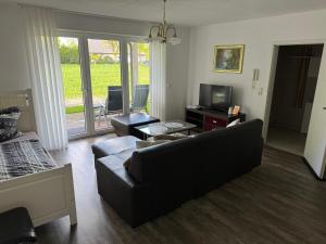 a living room with a couch and a tv at Ferienwohnung 24A Unten Links 3 Zimmer in Lathen