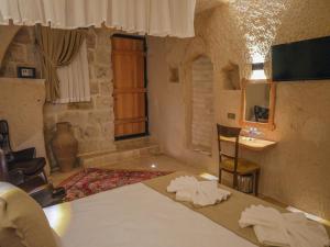 a bedroom with a bed and a sink in a room at Memories Cave House in Uçhisar