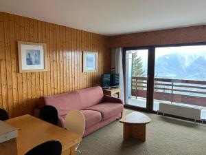 a living room with a couch and a large window at Diablerets SKI LIFT & MOUNTAIN apartments in Veysonnaz