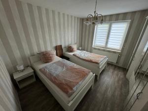 a small room with two beds and a window at Ferienwohnung 24A Unten Links 3 Zimmer in Lathen