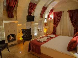 a bedroom with a bed and a fireplace at Memories Cave House in Uçhisar
