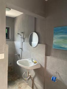 La salle de bains est pourvue d'un lavabo et d'un miroir. dans l'établissement Bruks Guest House, à Kumasi
