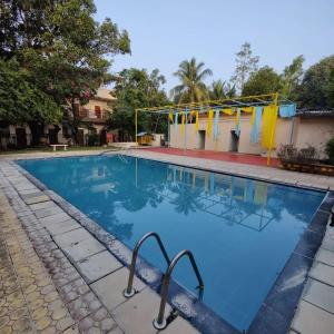 uma piscina com água azul num resort em Usha Resort em Pālghar