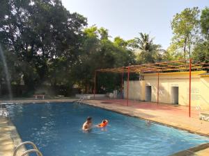 um homem e um rapaz numa piscina em Usha Resort em Pālghar