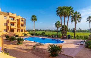 un complexe avec une piscine et des palmiers dans l'établissement Amazing Apartment In Los Alczares With Kitchen, à Los Alcázares