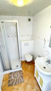 a bathroom with a shower and a toilet and a sink at Lust auf Meer - Ferienappartement in Cuxhaven