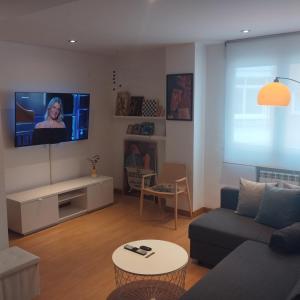Leon Riverside Flat في ليون: غرفة معيشة مع أريكة وتلفزيون على الحائط