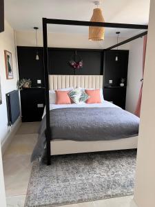 1 dormitorio con cama con dosel y almohadas rosas en The Old Nurseries Luxury Guest Suite en Lincoln