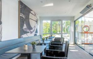 - une rangée de tables et de chaises dans une chambre avec fenêtres dans l'établissement Apartments Waterfront, à Sagard