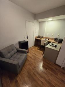 uma sala de estar com um sofá e uma mesa em LA RESIDENCE PAULISTA - Flat 806 - Residence Service + Academia + Piscina + Prox. Paulista em São Paulo
