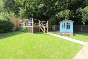 a play structure in a yard with a house at Detached Bungalow Private Hot Tub With Log Burner in Torquay