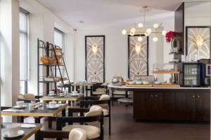 un restaurant avec des tables, des chaises et un comptoir dans l'établissement Hotel Elysées Bassano, à Paris