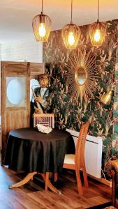 - une chambre avec une table et un mur fleuri dans l'établissement gîte la bohème, à Saint-Valery-sur-Somme