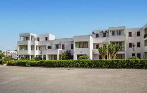 a large white apartment building with a parking lot at Pet Friendly Apartment in Isca sullo Ionio +4 photos