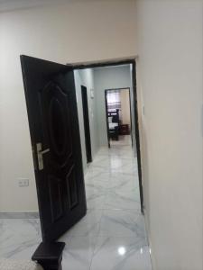a black door in a room with a hallway at 2 bedroom apartment in Tema