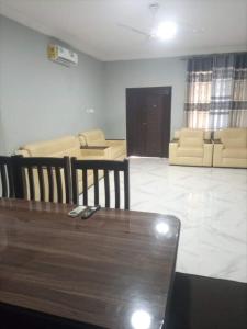 a living room with a table and chairs and a couch at 2 bedroom apartment in Tema