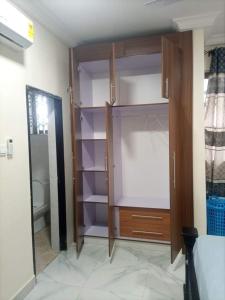 a closet with wooden shelves in a room at 2 bedroom apartment in Tema
