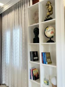 a white book shelf with books and a globe on it at DNA Villa Space in Buôn Dhă Prŏng