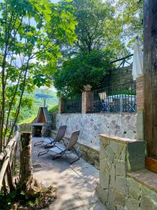 un patio con 2 sillas y una pared de piedra en Il Colle - Apartment Giglio, en Florencia