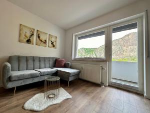 - un salon avec un canapé et une grande fenêtre dans l'établissement Ferienwohnung Rotenfelsblick, à Bad Kreuznach