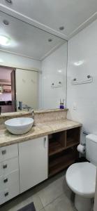 a bathroom with a sink and a toilet and a mirror at Apê BENTO com churrasqueira! in Bento Gonçalves