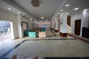 un vestíbulo con sillas y mesas en un edificio en فندق حياة دمنهور - Hayat Hotel Damnhour en Damanhûr