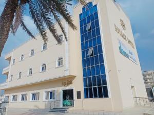um edifício com uma palmeira em frente em فندق حياة دمنهور - Hayat Hotel Damnhour em Damanhûr
