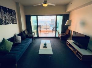 a living room with a couch and a table at Darwin City Suites with Harbour View in Darwin