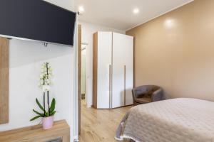 ein Schlafzimmer mit einem Bett und einem TV an der Wand in der Unterkunft Casa Eros in Bolano