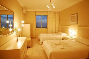 a hotel room with two beds and a mirror at Goldcity Otel Kargıcak in Alanya