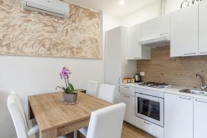 eine Küche mit einem Holztisch und weißen Schränken in der Unterkunft Casa Eros in Bolano
