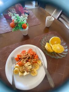 a plate of food with vegetables and oranges on a table at Hotel Pousada Paraiso Avaré in Avaré