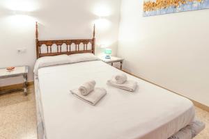 ein Schlafzimmer mit einem großen weißen Bett mit Handtüchern darauf in der Unterkunft Sant Carles 23 apartamento con vistas al mar in Girona