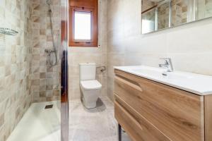 ein Badezimmer mit Toilette, Waschbecken und Spiegel in der Unterkunft Sant Carles 23 - apartamento con vistas al mar in Girona + 10 Fotos