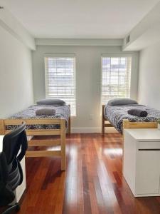 2 camas en una habitación con 2 ventanas en 440-Luxury Apt Near Light Rail, en Hoboken