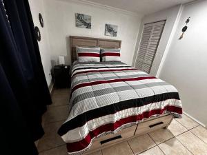 1 dormitorio con 1 cama grande con rayas blancas y negras en Miami Breeze Studio en Miami Gardens