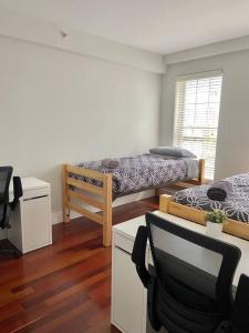 a room with two beds and a desk and a chair at 440-Luxury Apt Near Light Rail in Hoboken