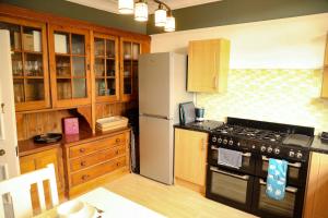 una cucina con fornelli e frigorifero di Stylishly decorated 3 bed home close to the sea in Hoylake on the Wirral Peninsula a Hoylake Altre 10 foto