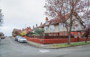 a house with cars parked on the side of a street at Stylishly decorated 3 bed home close to the sea on the Wirral Peninsula in Hoylake